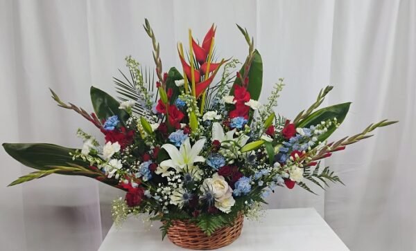 Blue and red basket, red roses, gladiolus, carnations, delphinium & lilies.
