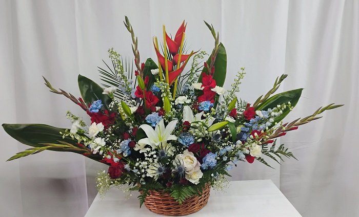 Blue and red basket, red roses, gladiolus, carnations, delphinium & lilies.