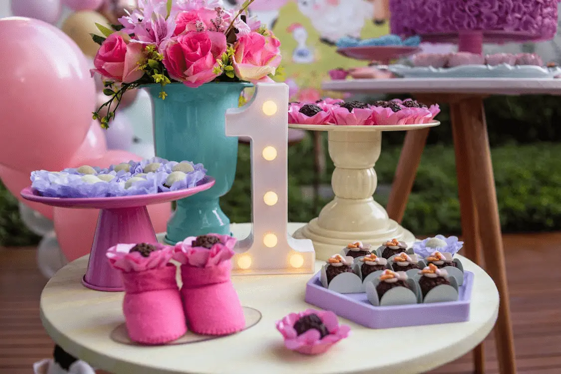 A birthday event for 1 year old kid can be seen with flowers and cakes