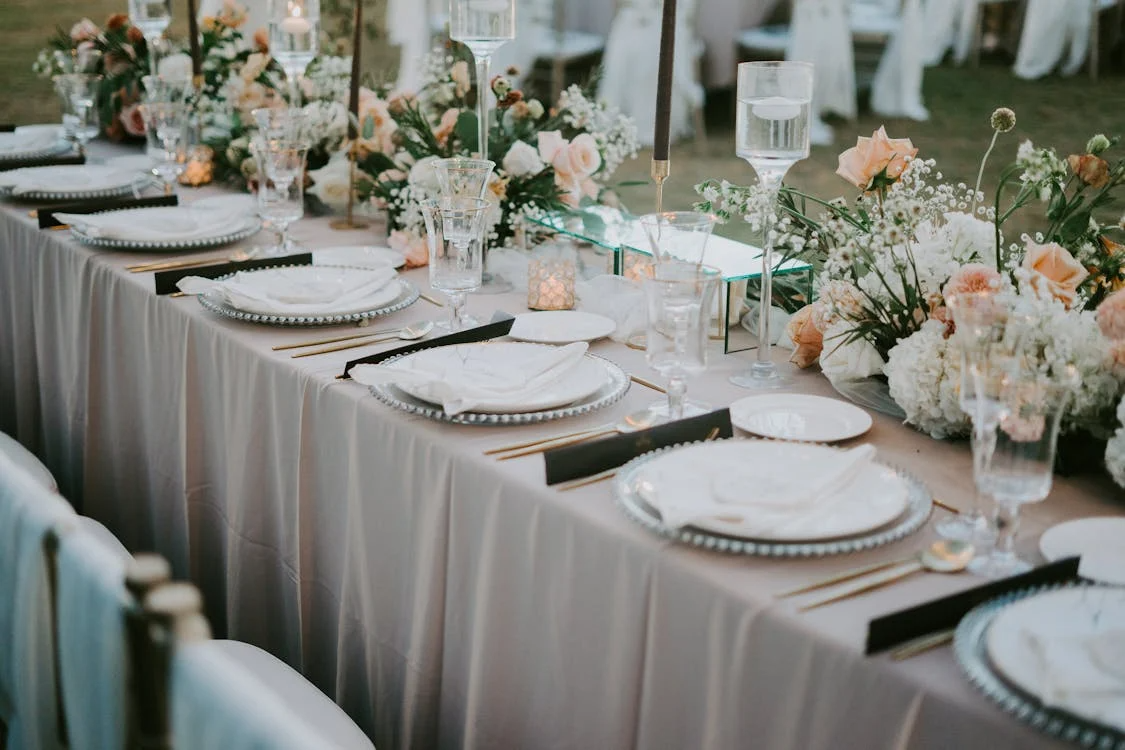 An event table can be seen with utensils and matching flowers