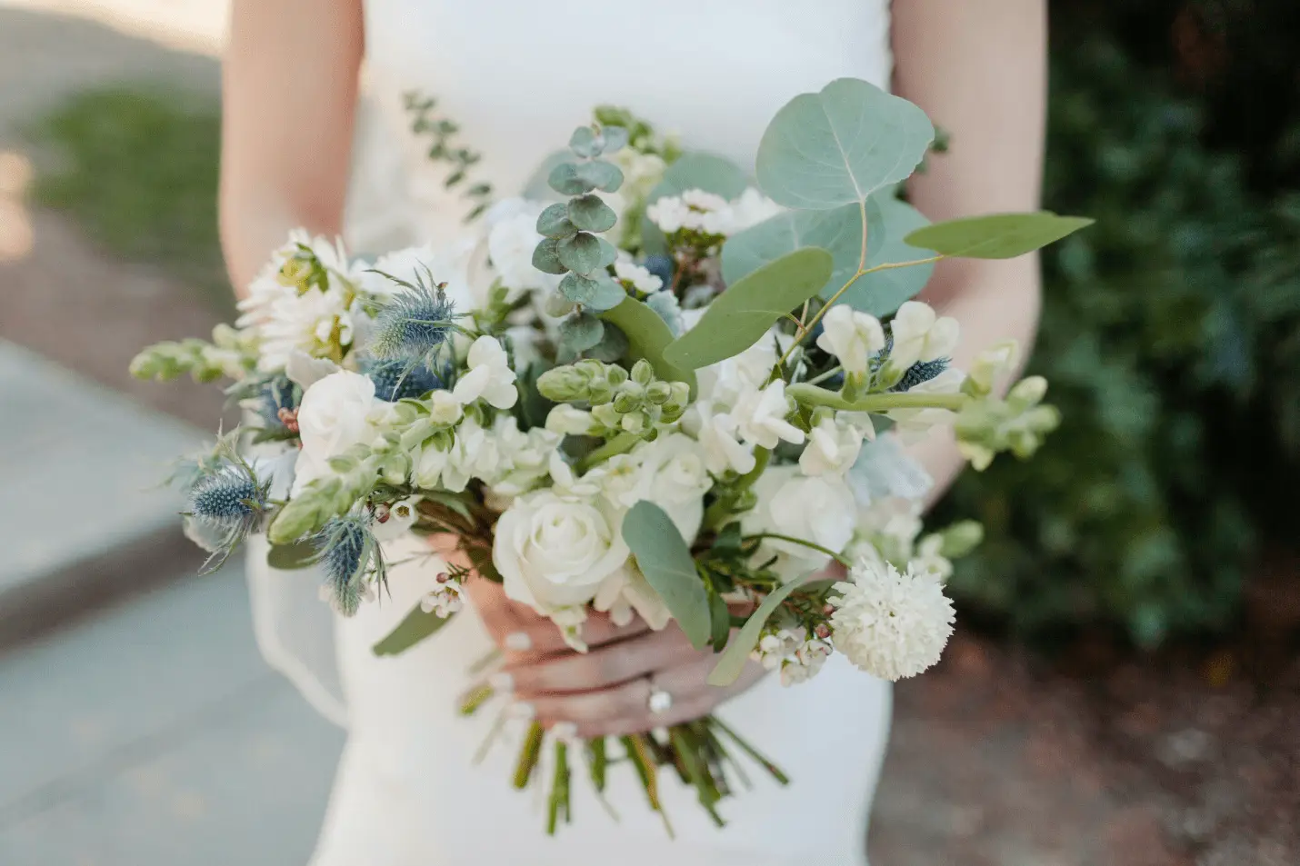 a bride in white clothes holding a bouquet