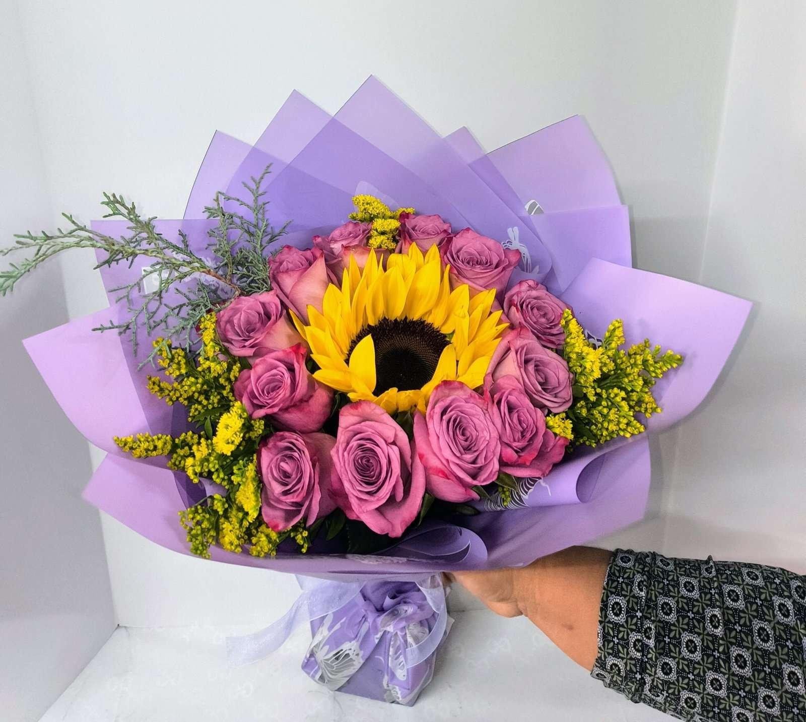 12 Purple roses and a sunflower wrapped